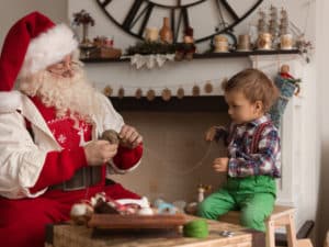 Père Noël et petit garçon préparant un cadeau couture