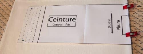 La découpe de la ceinture dans le jersey de coton, sur la pliure