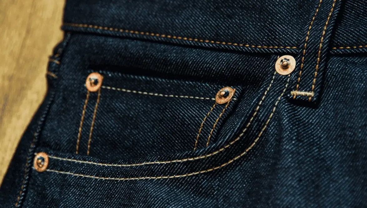 Détail couture sur un pantalon jean's denim avec rivets