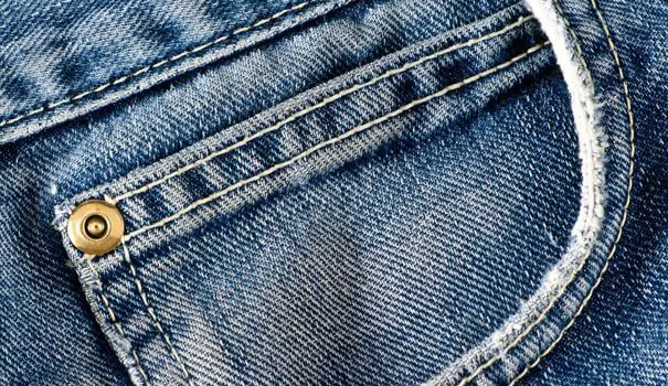 Détail couture d'une poche de jean's avec rivet